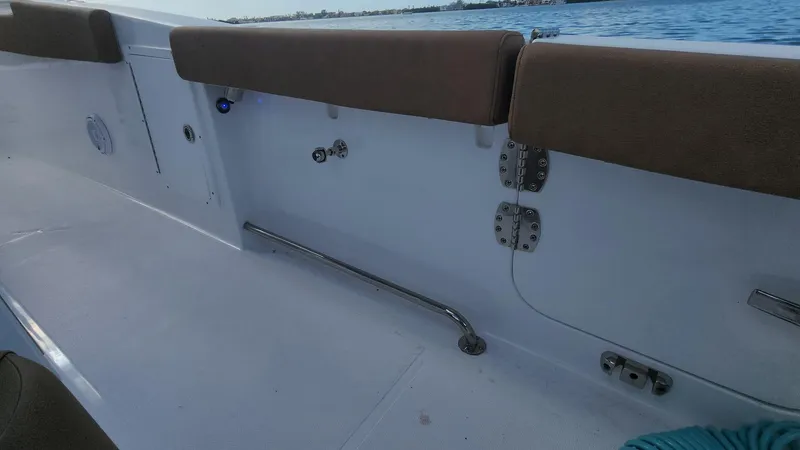 Slide: The Image of 2024 Sea Hunt Ultra 275 SE boat interior with cushioned seating and ocean view. - 26