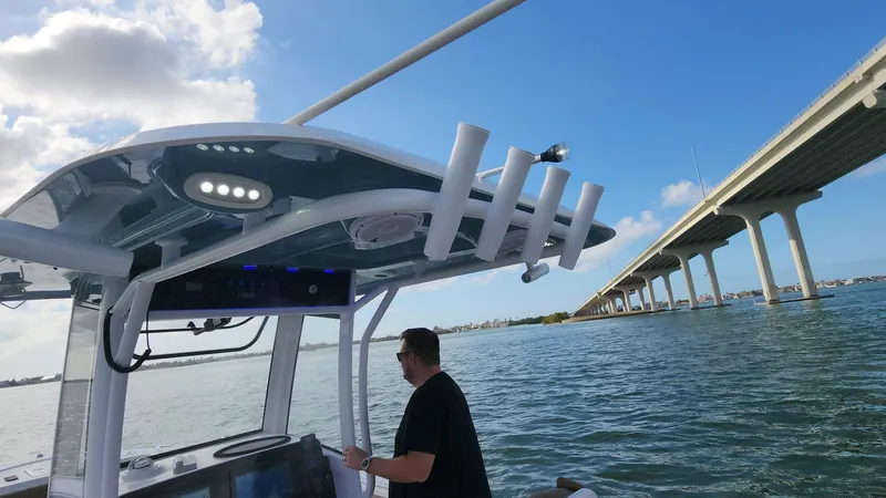 Slide: The Image of 2024 Sea Hunt Ultra 275 SE boat cruising near a bridge on a sunny day. - 34