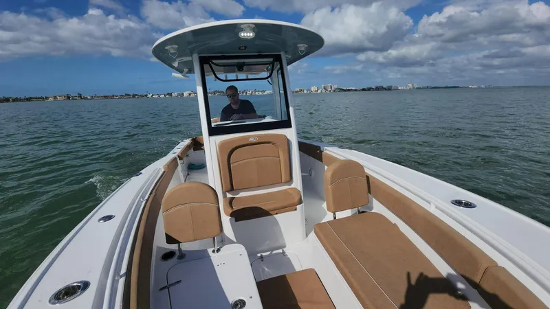 Slide: The Image of 2024 Sea Hunt Ultra 275 SE boat cruising on open water under blue skies. - 35