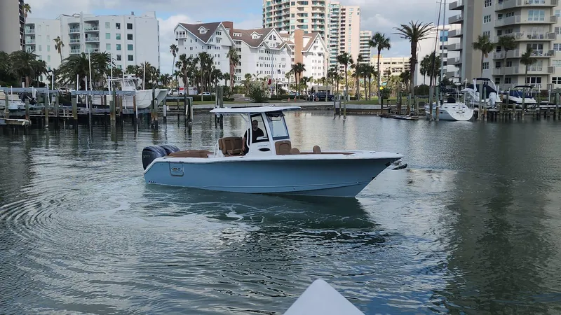 Slide: The Image of 2024 Sea Hunt Ultra 275 SE boat in a marina with waterfront buildings. - 39