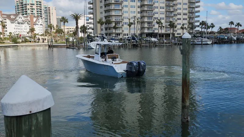 Slide: The Image of 2024 Sea Hunt Ultra 275 SE boat in a marina with waterfront buildings. - 45