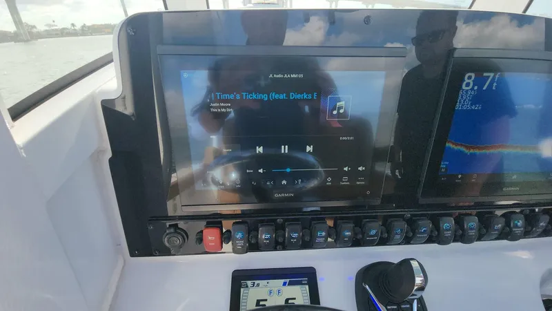 Slide: The Image of 2024 Sea Hunt Ultra 275 SE dashboard with music and navigation displays. - 46