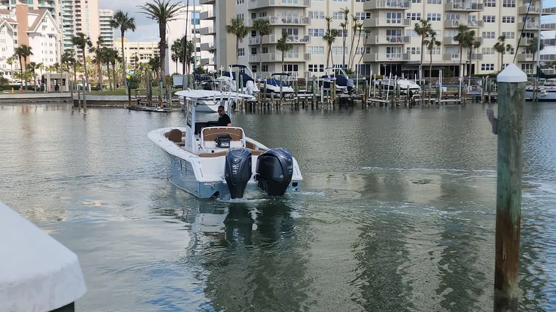 Slide: The Image of 2024 Sea Hunt Ultra 275 SE boat in marina, cityscape background. - 48