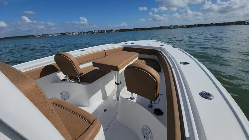 Slide: The Image of 2024 Sea Hunt Ultra 275 SE boat interior with seating on calm water. - 6