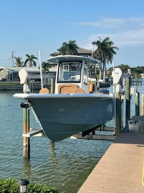Slide: The Image of 2024 Sea Hunt Ultra 275 SE boat docked by palm trees. - 8