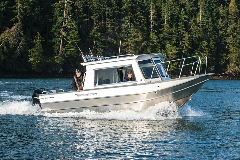 Slide: The Image of 2024 Spartan 220 Maximus boat with outboard motor, parked on roadside. - 10