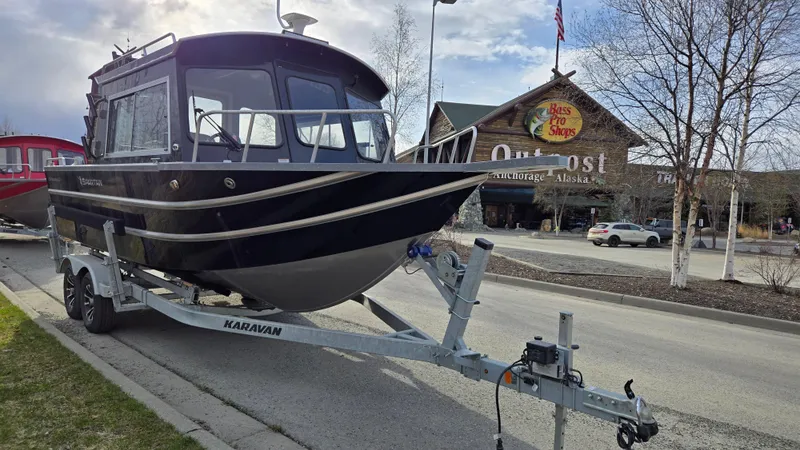 Slide: The Image of 2024 Spartan 220 Maximus boat on trailer, parked outdoors under cloudy sky. - 3