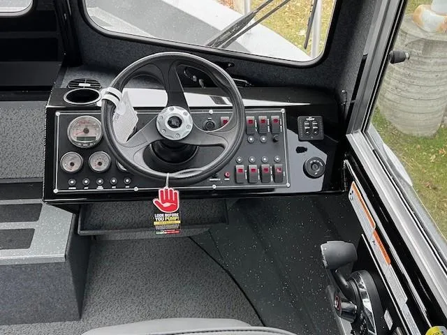 Slide: The Image of 2024 Spartan 220 Maximus boat on Karavan trailer, parked on a residential street. - 7