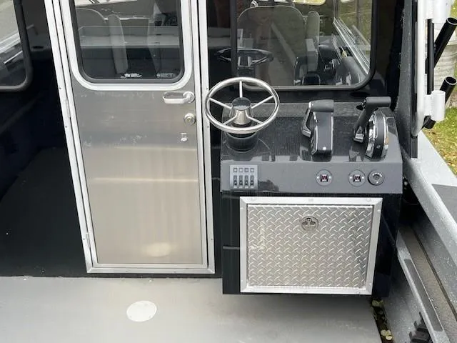 Slide: The Image of 2024 Spartan 220 Maximus boat on trailer, parked on roadside with trees in background. - 8