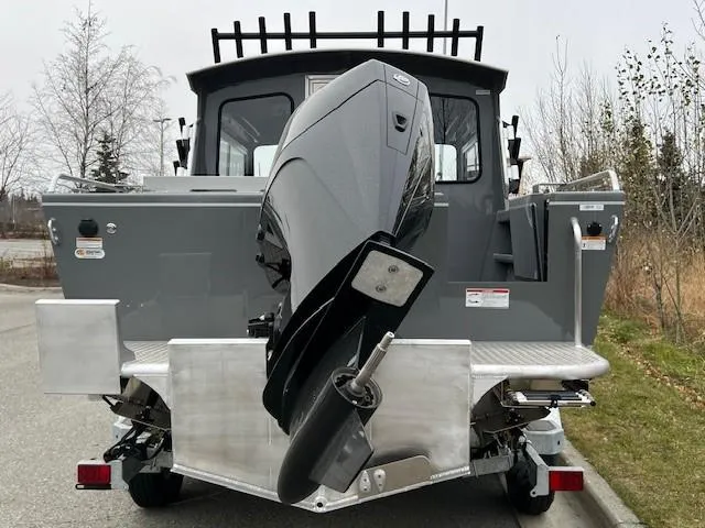 Slide: The Image of 2024 Spartan 220 Maximus boat with powerful outboard motor, parked on a paved surface. - 4