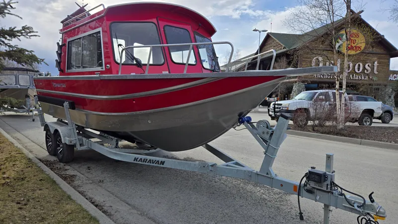 Slide: The Image of 2024 Spartan 220 Maximus boat on trailer, parked in urban setting. - 1