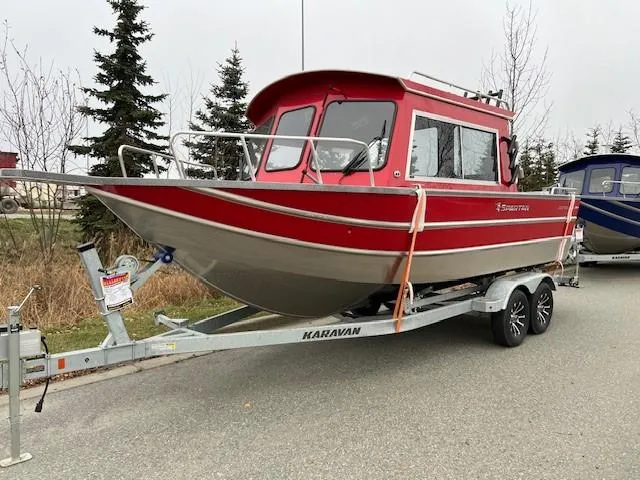 Slide: The Image of 2024 Spartan 220 Maximus boat in red on a Karavan trailer, parked outdoors. - 3