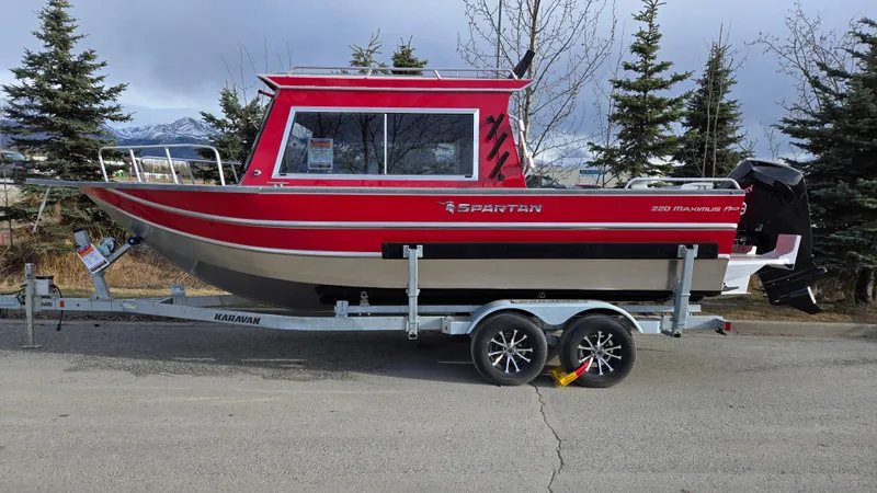 Slide: The Image of 2024 Spartan 220 Maximus boat on trailer, red and black design, parked outdoors. - 4