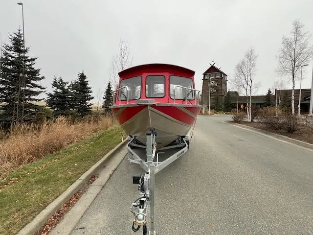 Slide: The Image of 2024 Spartan 220 Maximus boat on trailer, parked on a suburban road. - 5