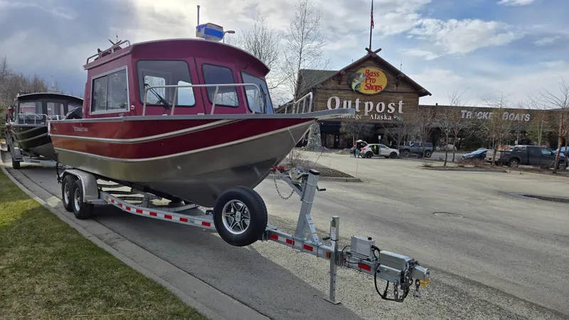 Slide: The Image of 2024 Spartan 24 MAXIMUS PRO XL boat on trailer outside outdoor store. - 2