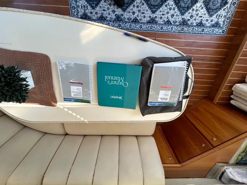 Slide: The Image of Interior of 1999 Silverton 351 Sedan Cruiser with manuals on a table. - 24
