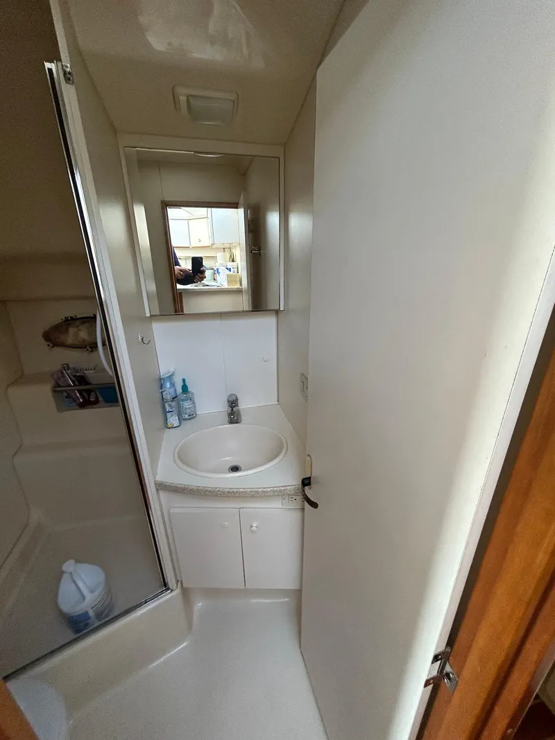 Slide: The Image of 1999 Silverton 351 Sedan Cruiser bathroom with sink, mirror, and shower. - 25
