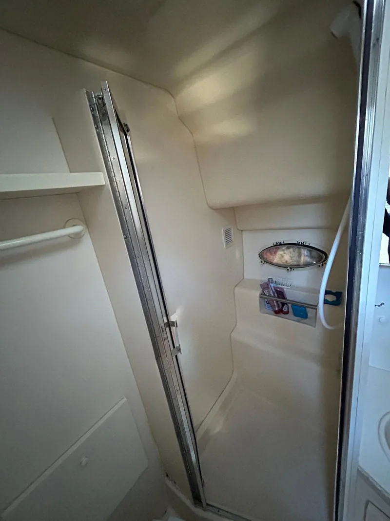 Slide: The Image of 1999 Silverton 351 Sedan Cruiser bathroom with shower and storage shelves. - 27