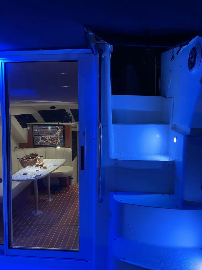 Slide: The Image of 1999 Silverton 351 Sedan Cruiser interior with blue lighting and dining area. - 3
