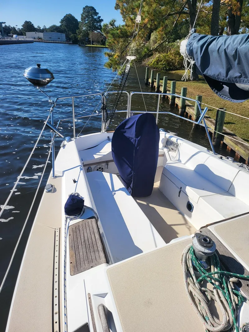 Slide: The Image of 1988 Catalina 30 sailboat docked by a serene riverside. - 20