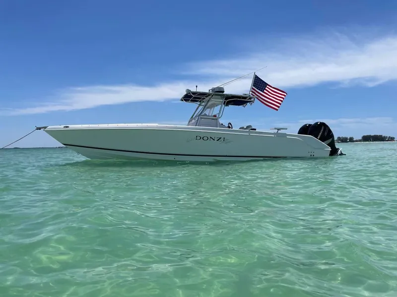 Slide: The Image of 2004 Donzi 35 ZF Open boat with American flag on clear water. - 1