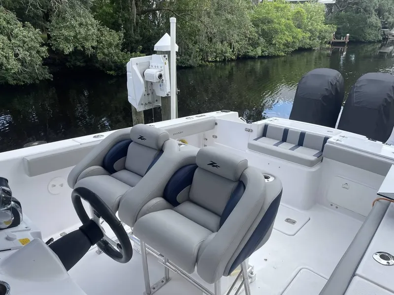 Slide: The Image of 2004 Donzi 35 ZF Open boat interior with dual seats, steering wheel, and lush river backdrop. - 14