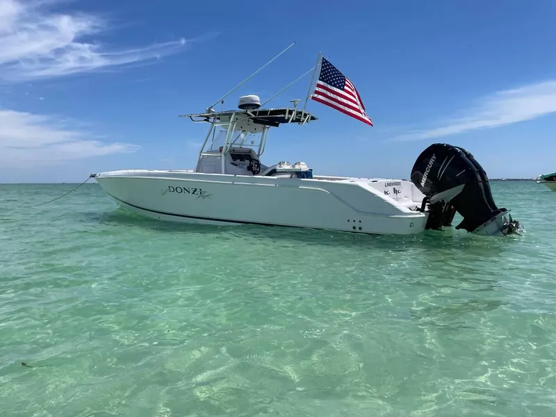 Slide: The Image of 2004 Donzi 35 ZF Open boat in clear water with American flag. - 2