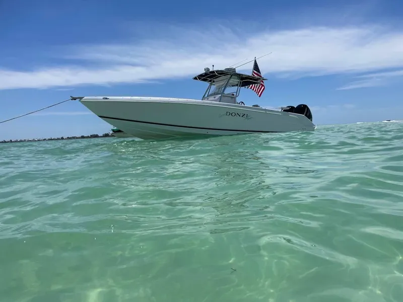 Slide: The Image of 2004 Donzi 35 ZF Open boat on clear turquoise water, under a blue sky. - 4