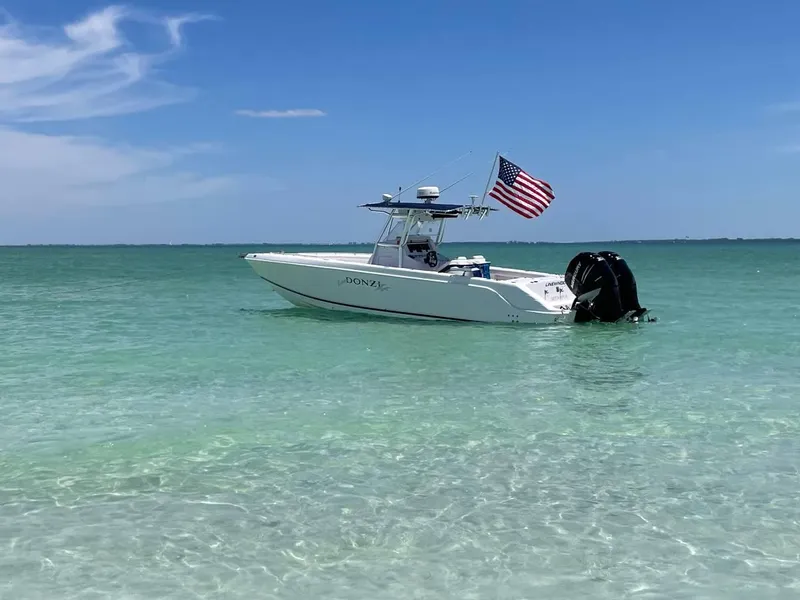 Slide: The Image of 2004 Donzi 35 ZF Open boat with American flag on clear turquoise water. - 9