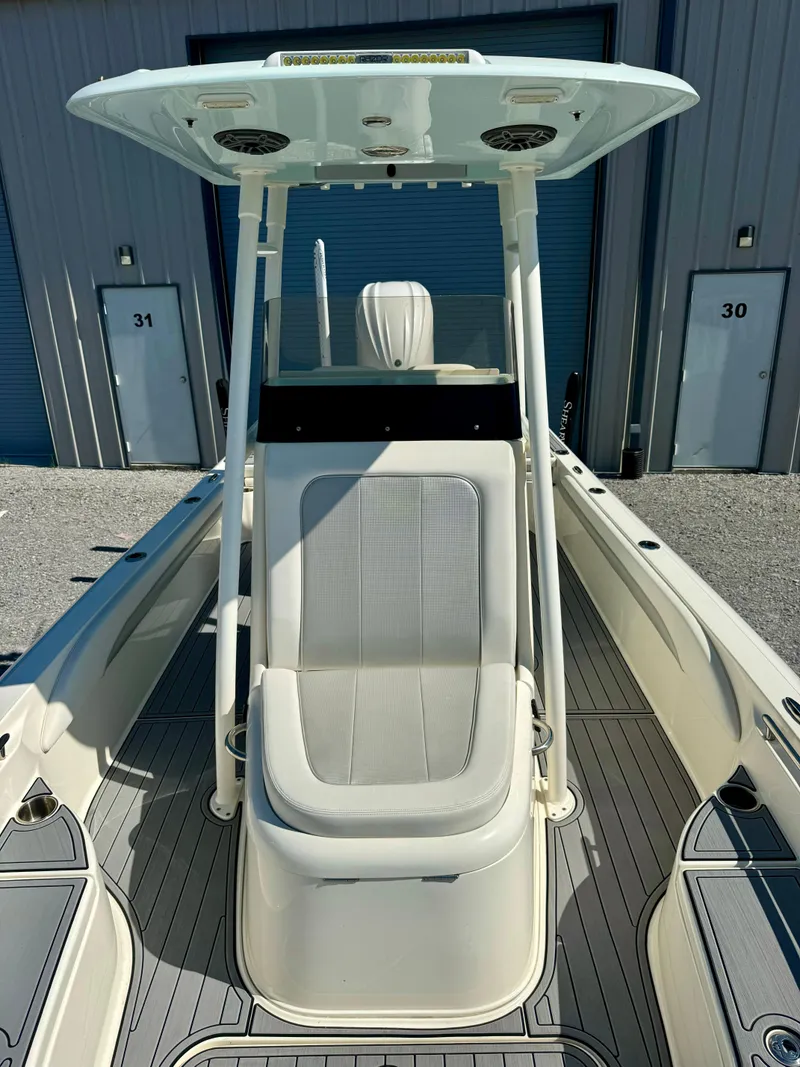 Slide: The Image of 2022 ShearWater 260 Carolina Flair boat with T-top and seating, docked near storage units. - 8