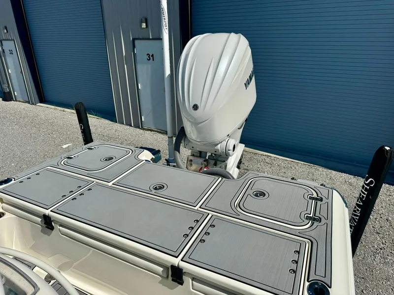 Slide: The Image of 2022 ShearWater 260 Carolina Flair boat with Yamaha outboard motor, docked near storage units. - 9