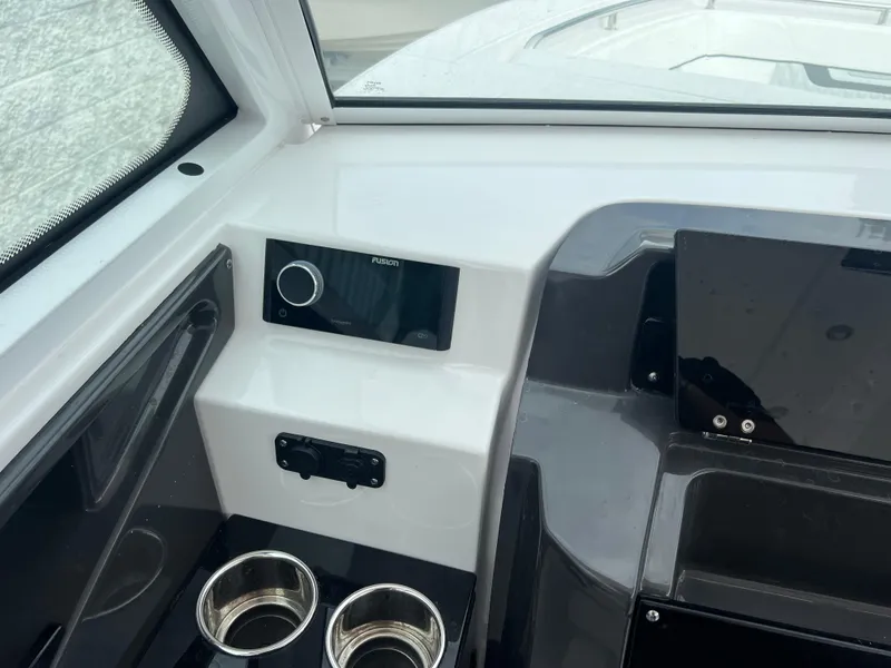 Slide: The Image of 2024 Blackfin 272 DC boat dashboard with modern controls and cup holders. - 15