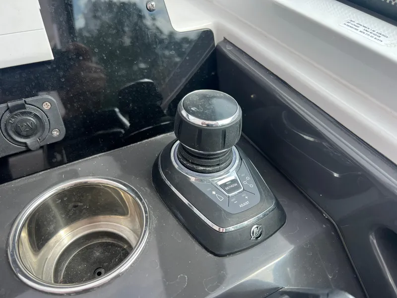Slide: The Image of Joystick control on 2024 Blackfin 272 DC boat dashboard, next to a cup holder. - 2