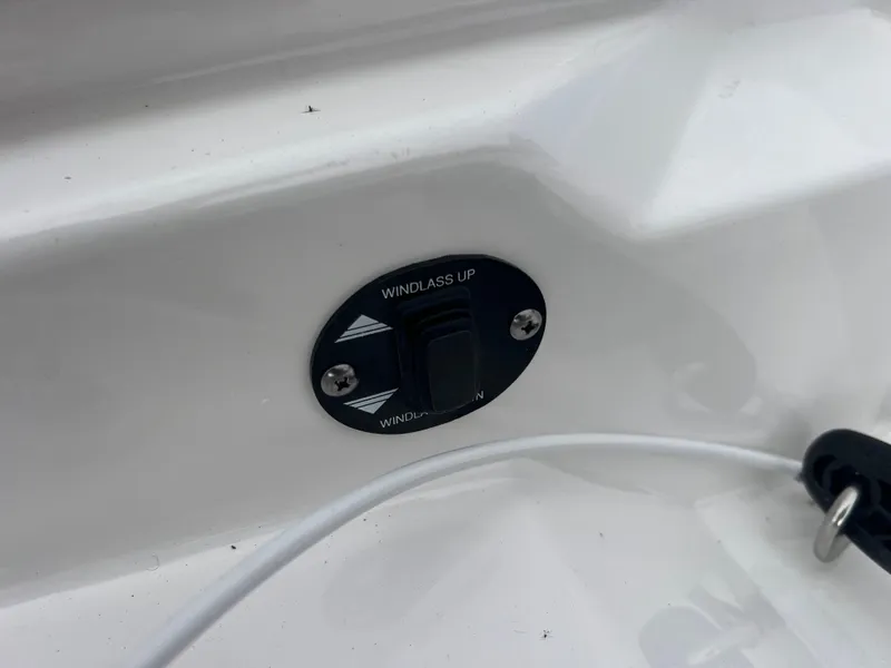 Slide: The Image of 2024 Blackfin 272 DC windlass control switch on white boat surface. - 27