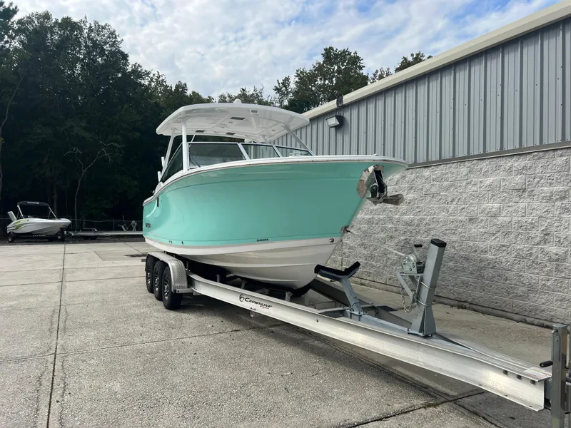 Slide: The Image of 2024 Blackfin 272 DC boat on trailer, parked outdoors near a building. - 33