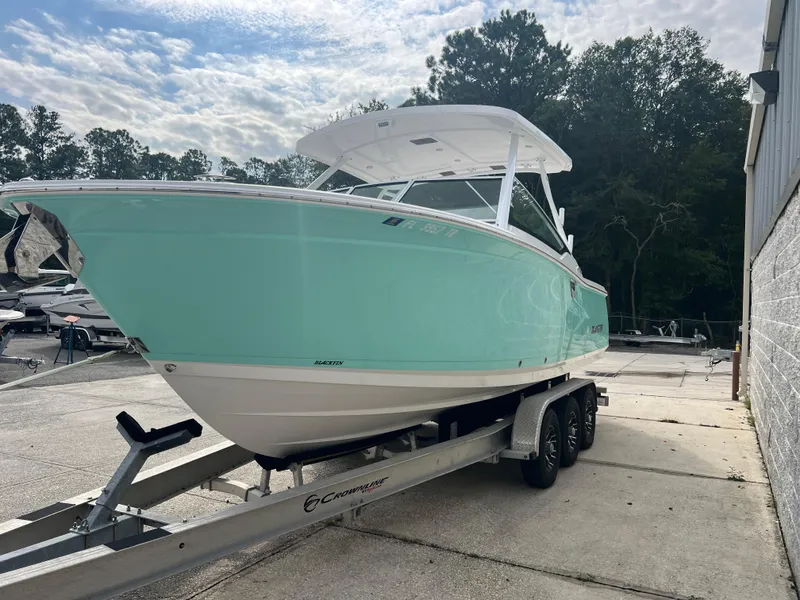 Slide: The Image of 2024 Blackfin 272 DC boat on trailer, mint green hull, parked outdoors. - 35