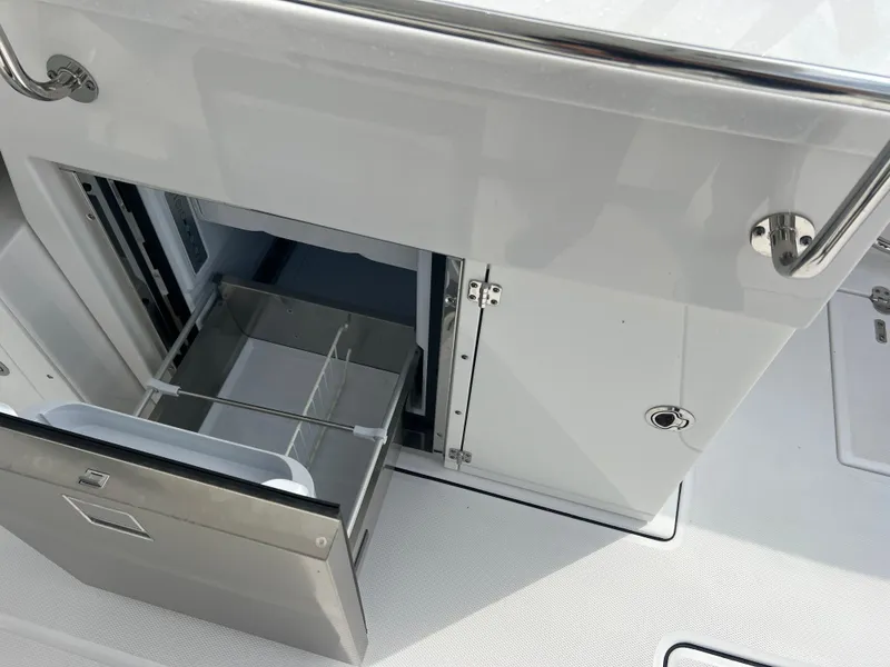 Slide: The Image of 2024 Blackfin 272 DC boat interior with open storage compartment and stainless steel details. - 46