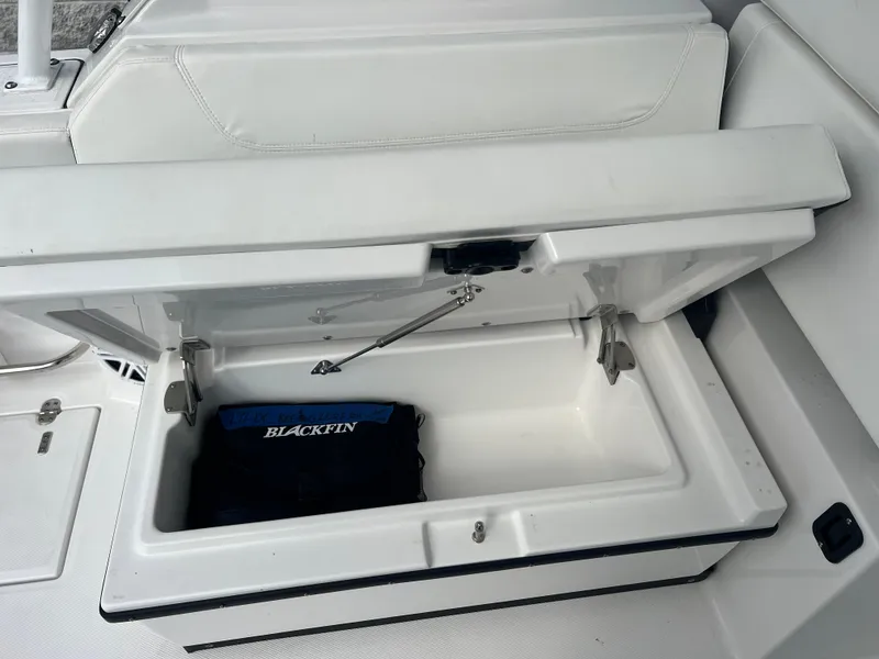 Slide: The Image of 2024 Blackfin 272 DC boat storage compartment with Blackfin-branded item inside. - 49