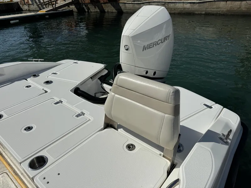 Slide: The Image of 2022 Boston Whaler 250 Dauntless boat with Mercury engine, docked on calm water. - 13