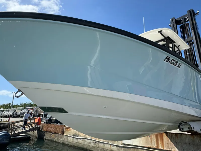 Slide: The Image of 2022 Boston Whaler 250 Dauntless boat docked, viewed from below, clear sky background. - 17
