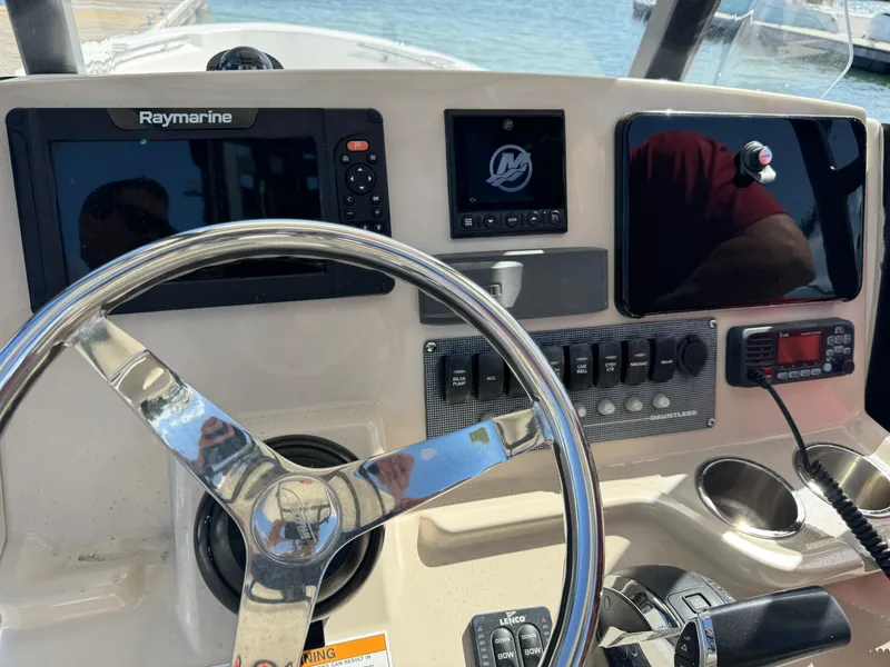 Slide: The Image of Boston Whaler 250 Dauntless 2022 dashboard with steering wheel and navigation equipment. - 9