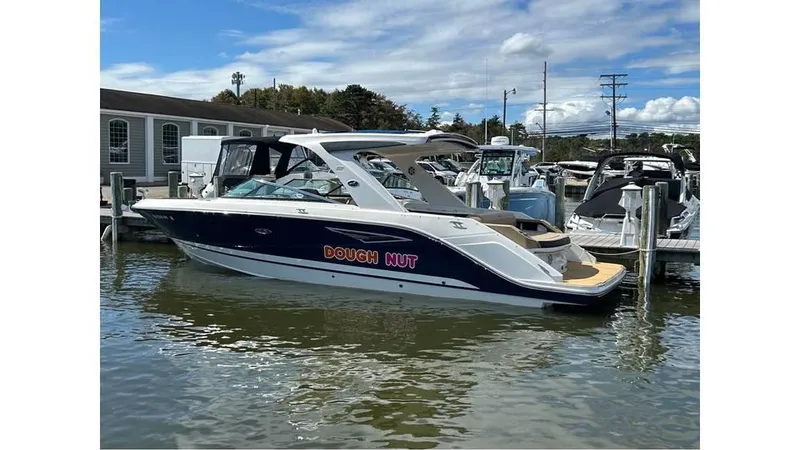The Image of 2019 Sea Ray 310 SLX boat docked in marina under blue sky. - 0