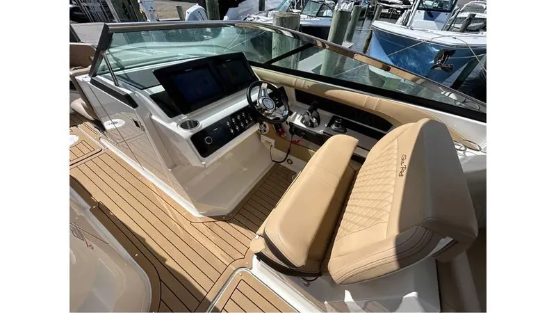 Slide: The Image of 2019 Sea Ray 310 SLX boat interior with modern dashboard and tan seating. - 12