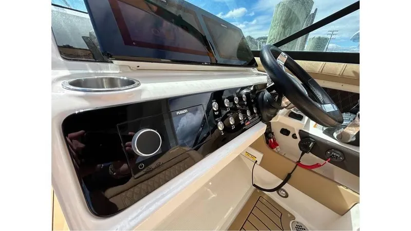 Slide: The Image of 2019 Sea Ray 310 SLX boat dashboard with modern controls and steering wheel. - 15