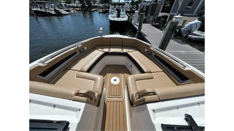 Slide: The Image of 2019 Sea Ray 310 SLX boat with luxurious tan seating at a marina. - 16