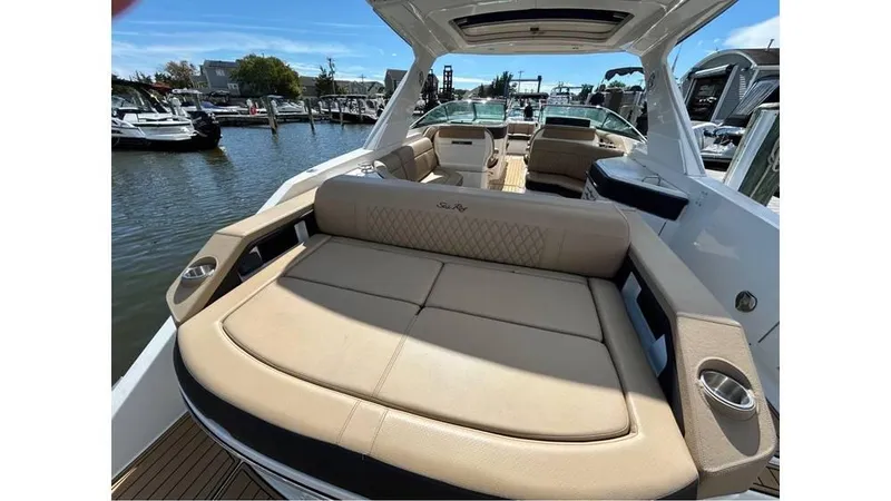 Slide: The Image of 2019 Sea Ray 310 SLX luxury boat with spacious seating at a marina. - 2
