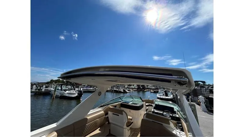 Slide: The Image of 2019 Sea Ray 310 SLX boat docked under sunny blue sky. - 4
