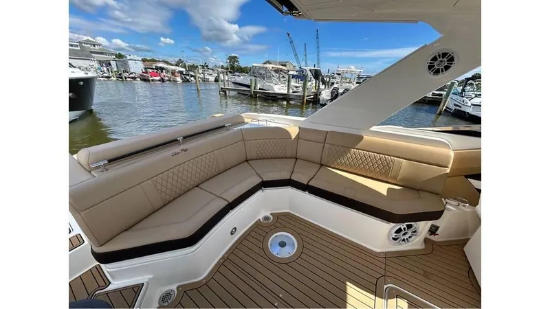 Slide: The Image of 2019 Sea Ray 310 SLX boat interior with tan seating and waterfront view. - 5