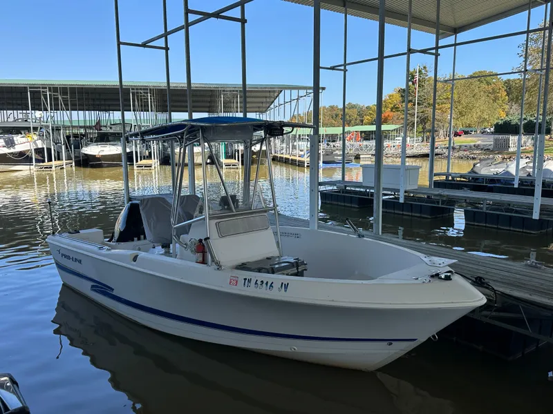 The Image of 2000 Pro-Line 20 Sport boat docked in a marina under a covered area. - 1
