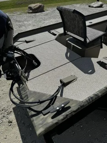 Slide: The Image of 2024 SeaArk 31652 CRAPPIE boat with camo design and seating, parked on gravel. - 5